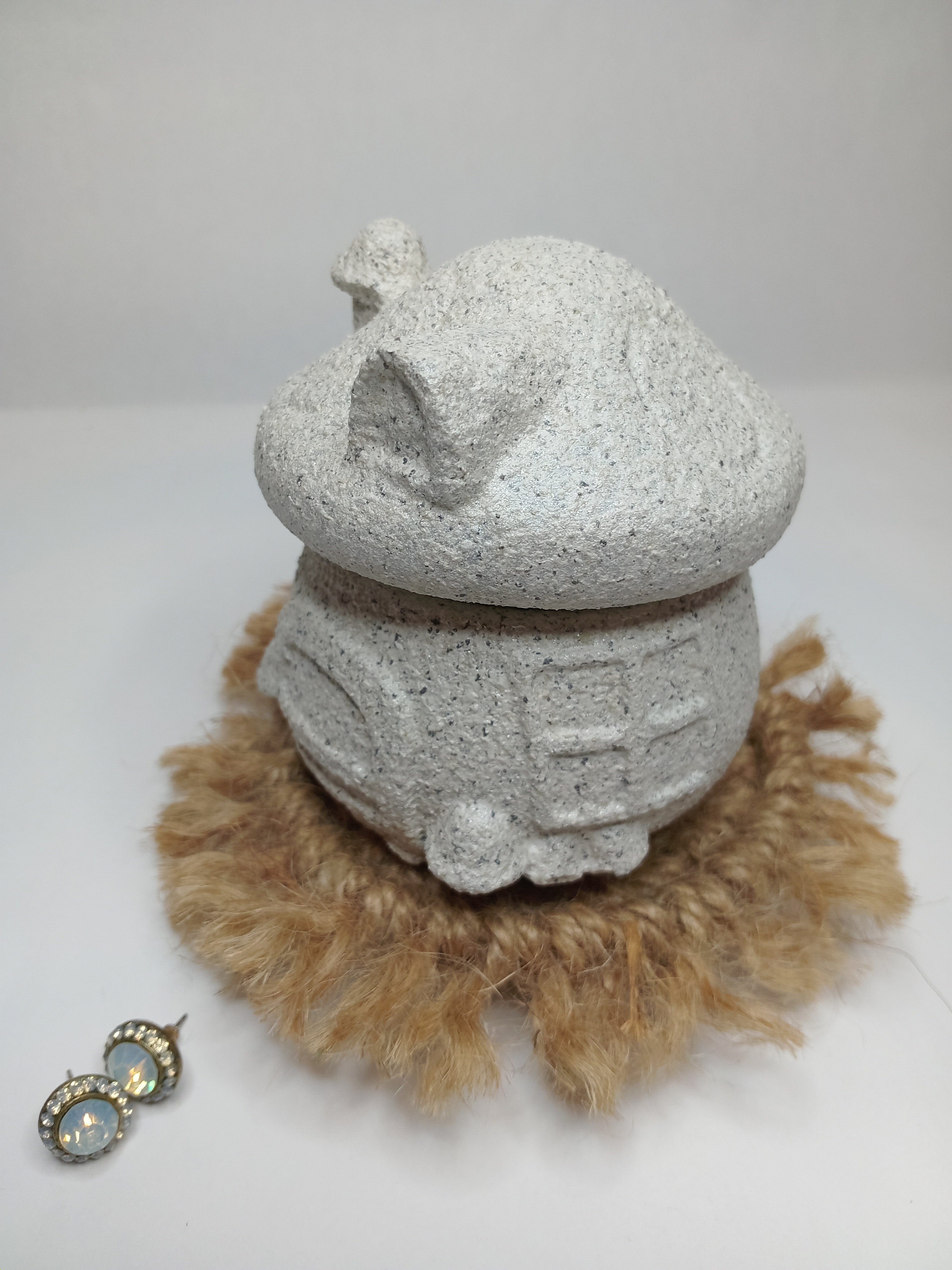 Decorative concrete mushroom trinket house with a stone textured surface and natural fiber on a white background